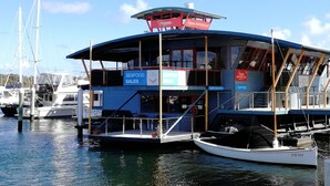 A ferry with a blue and white exterior, featuring a 'Seafood Sales' sign and a 'Ferry Seafood' sign. - Banjo Paterson Motor Inn (Lakes Entrance)