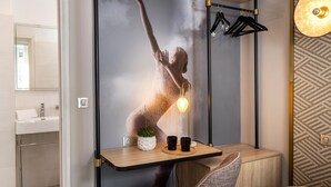 A modern bathroom with a large mirror, a sink, and a towel rack. - Hôtel Nude Paris - Color Vision (Paris)