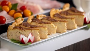 Une assiette avec des parts de gâteau au fromage et des tomates cerises.