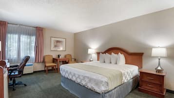A hotel room with a large bed, two bedside tables, a desk, and a chair.