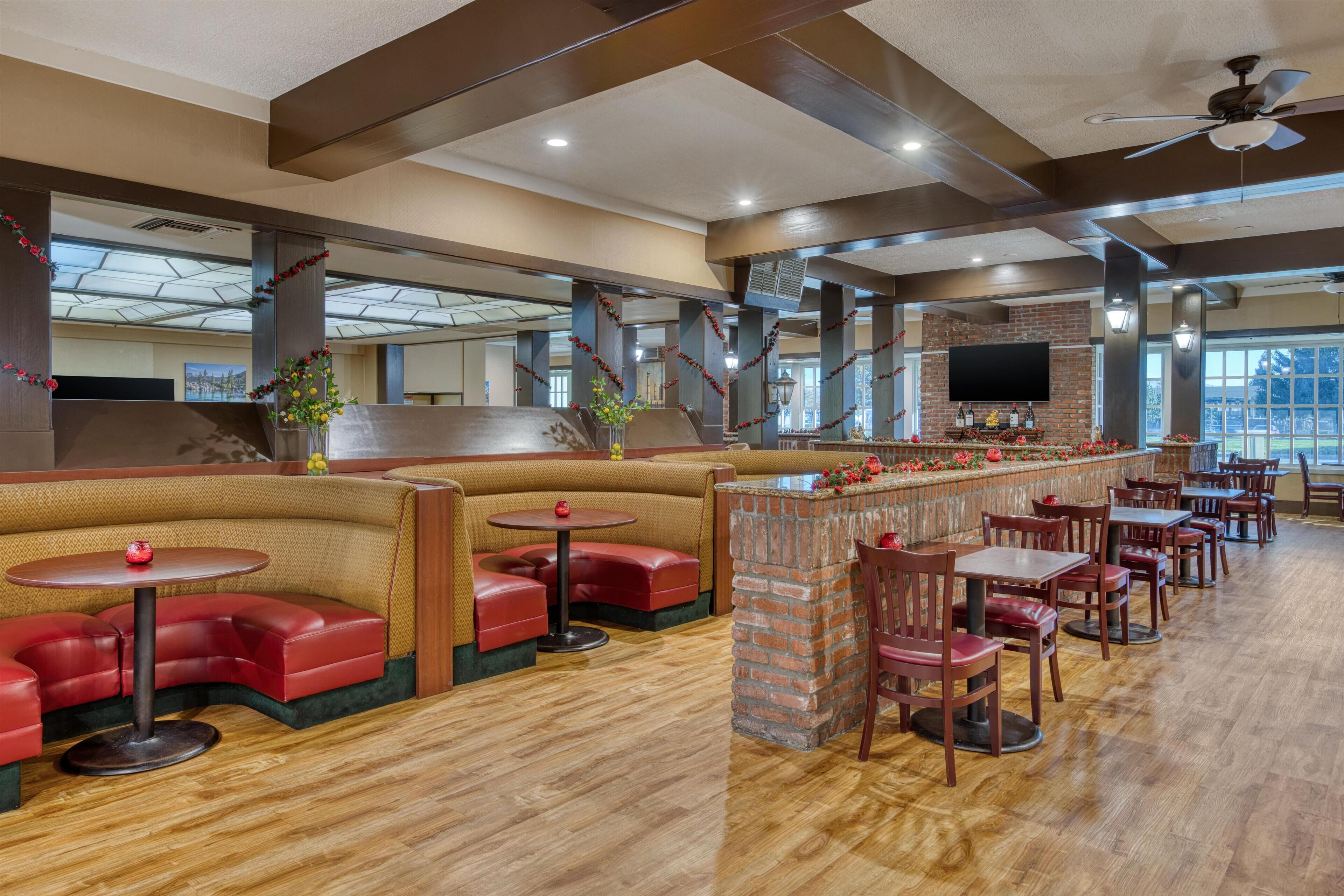A restaurant with booths, tables, and a bar area.