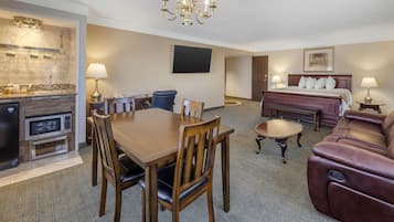 Une chambre d’hôtel comprenant un coin repas, une cuisine, un espace de vie avec un canapé et un lit.