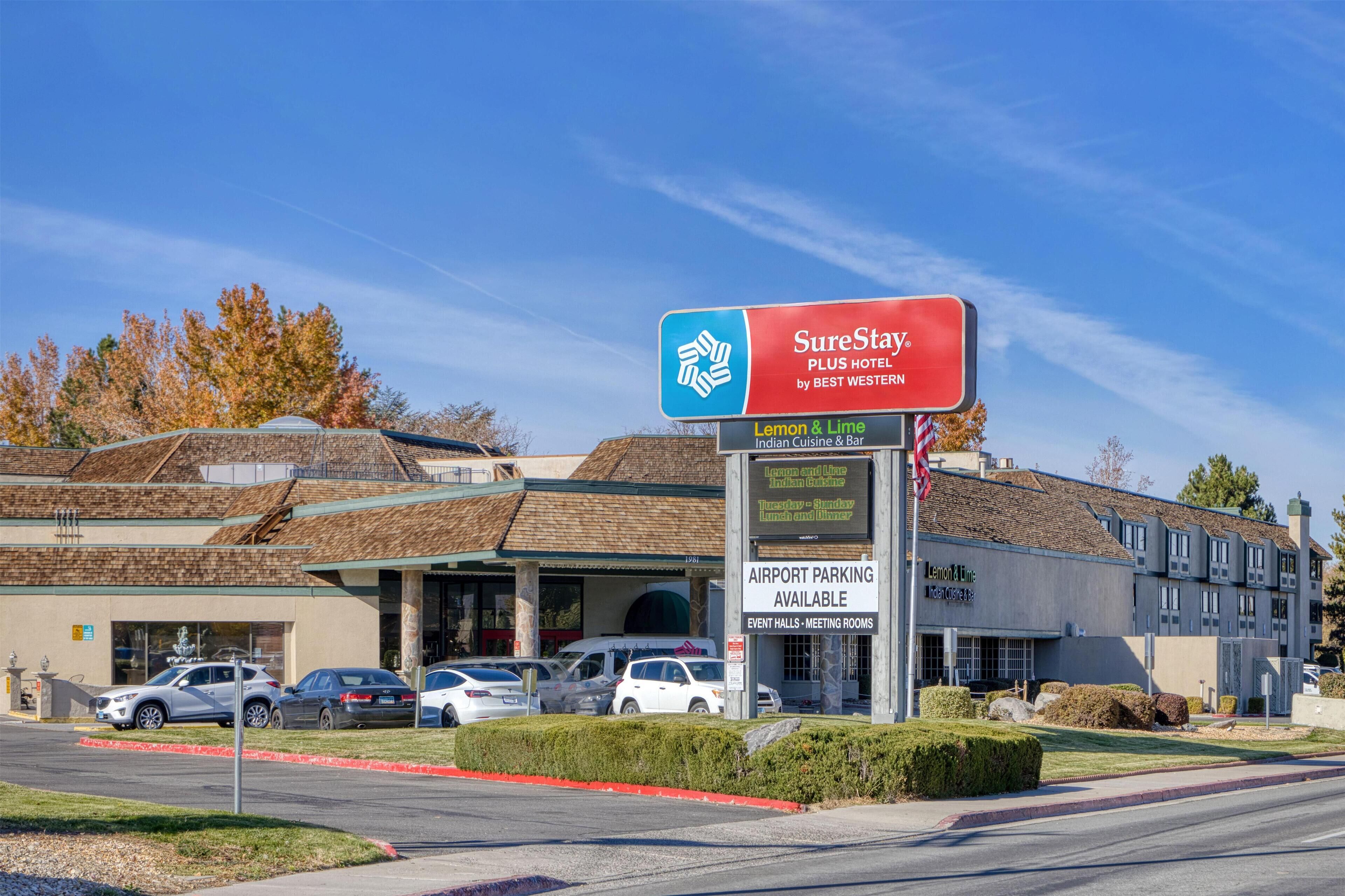 Um hotel com uma placa indicando SureStay by Best Western, estacionamento para o aeroporto e salões de eventos.