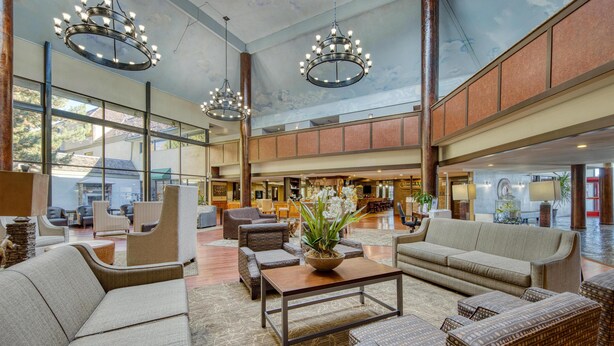 A spacious lobby with high ceilings, large windows, and modern furniture. - SureStay Plus Hotel by Best Western Reno Airport (Reno)