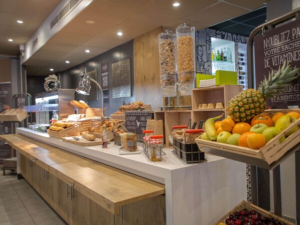 En frukostbuffé med ett varierat utbud av mat och en skylt på franska.