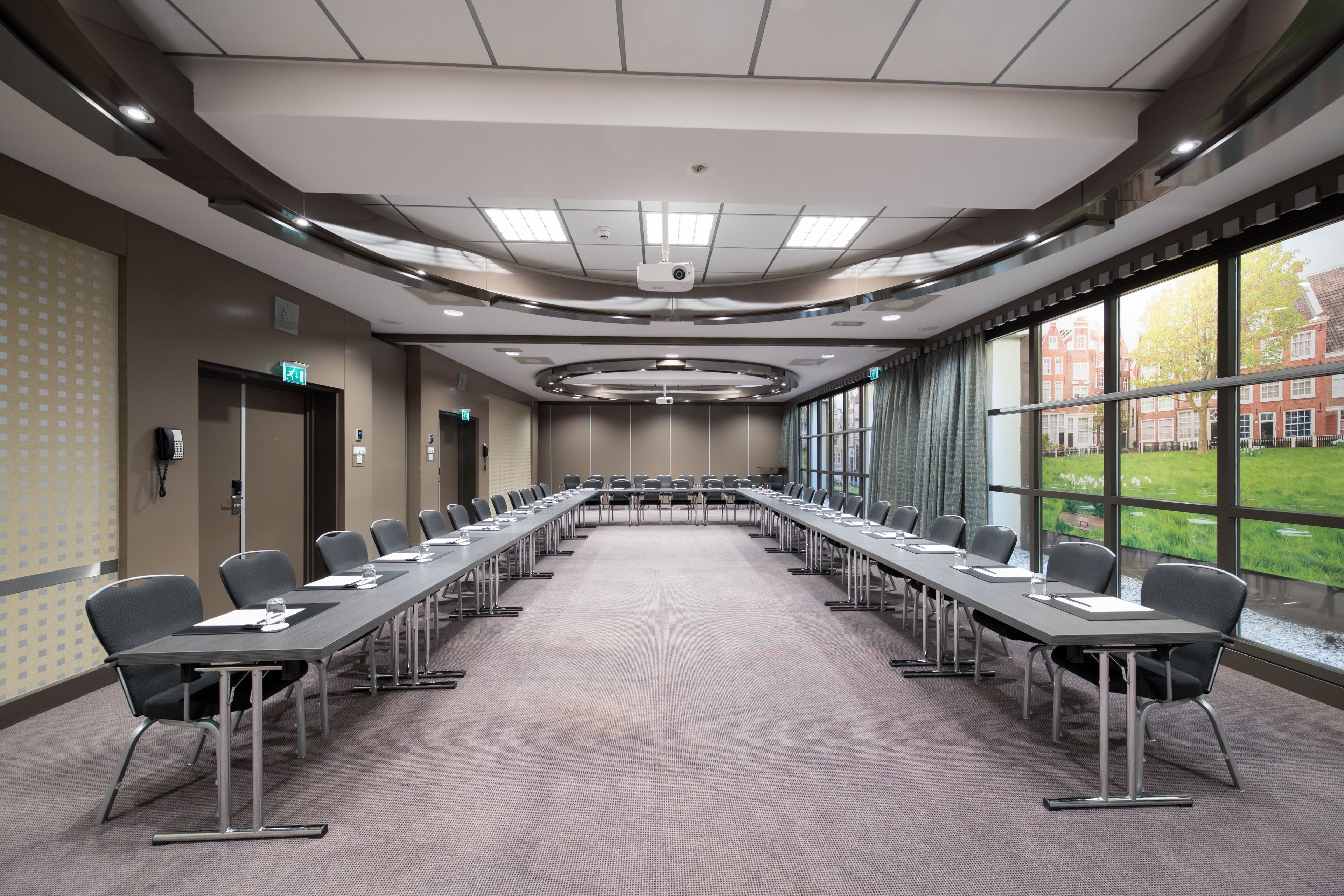 A conference room with a long table, chairs, and a projector.