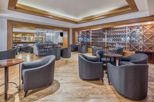 A modern lounge area with seating and a wine cellar.