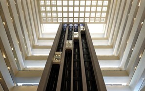 A modern building with a central atrium, multiple floors, and a grid of windows.