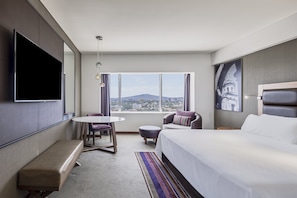 Relax in a spacious room with a large bed, flat-screen TV, and seating area.