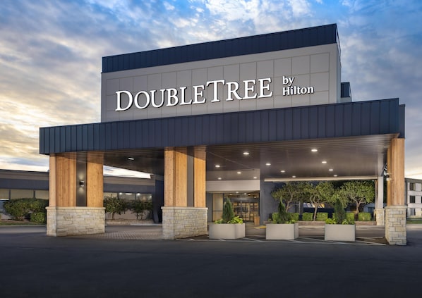Entrada de un hotel con un letrero que dice "DOUBLETREE by Hilton".