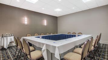 A conference room with a long table, chairs, and a white tablecloth.