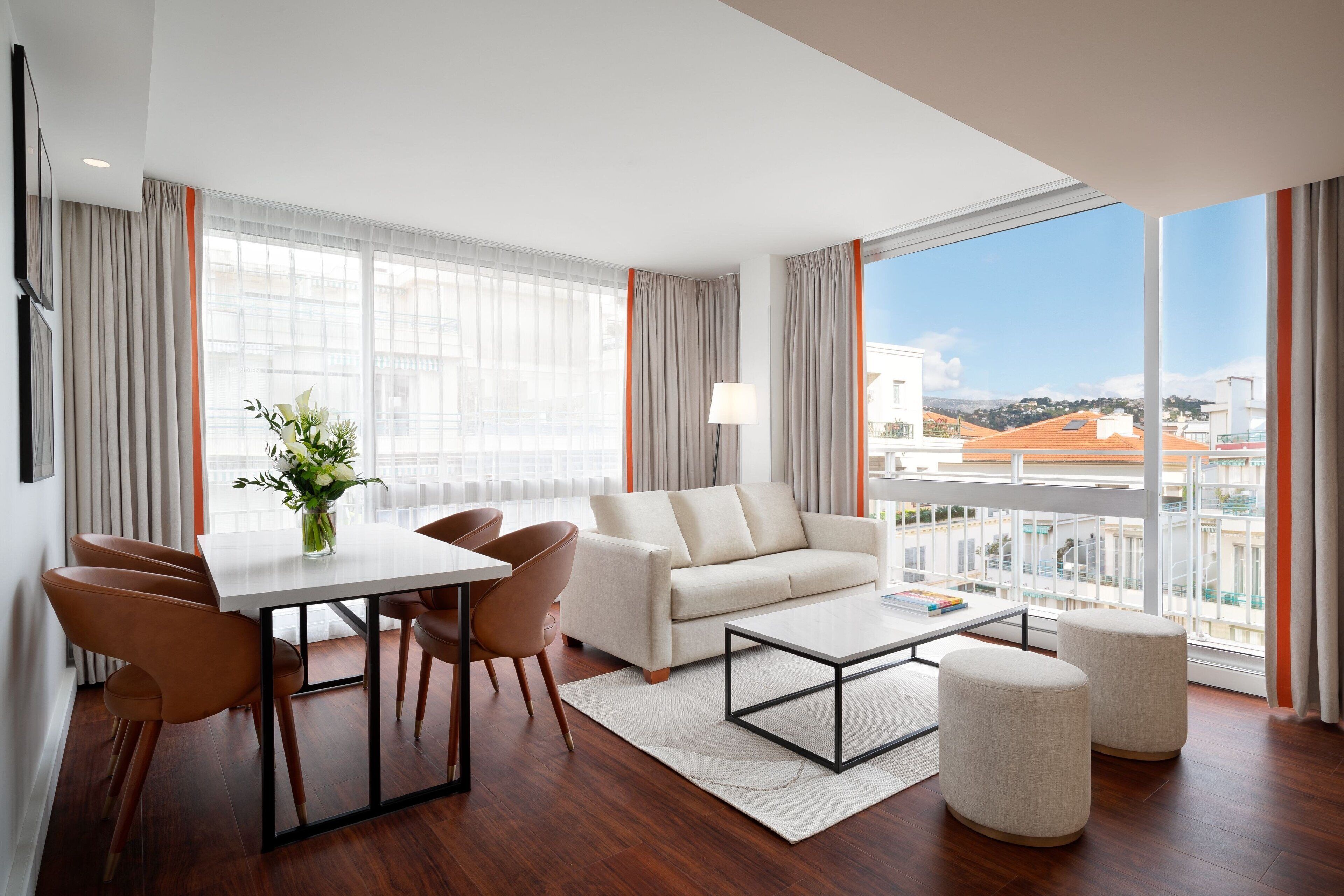 A modern living room with a sofa, coffee table, and dining area.
