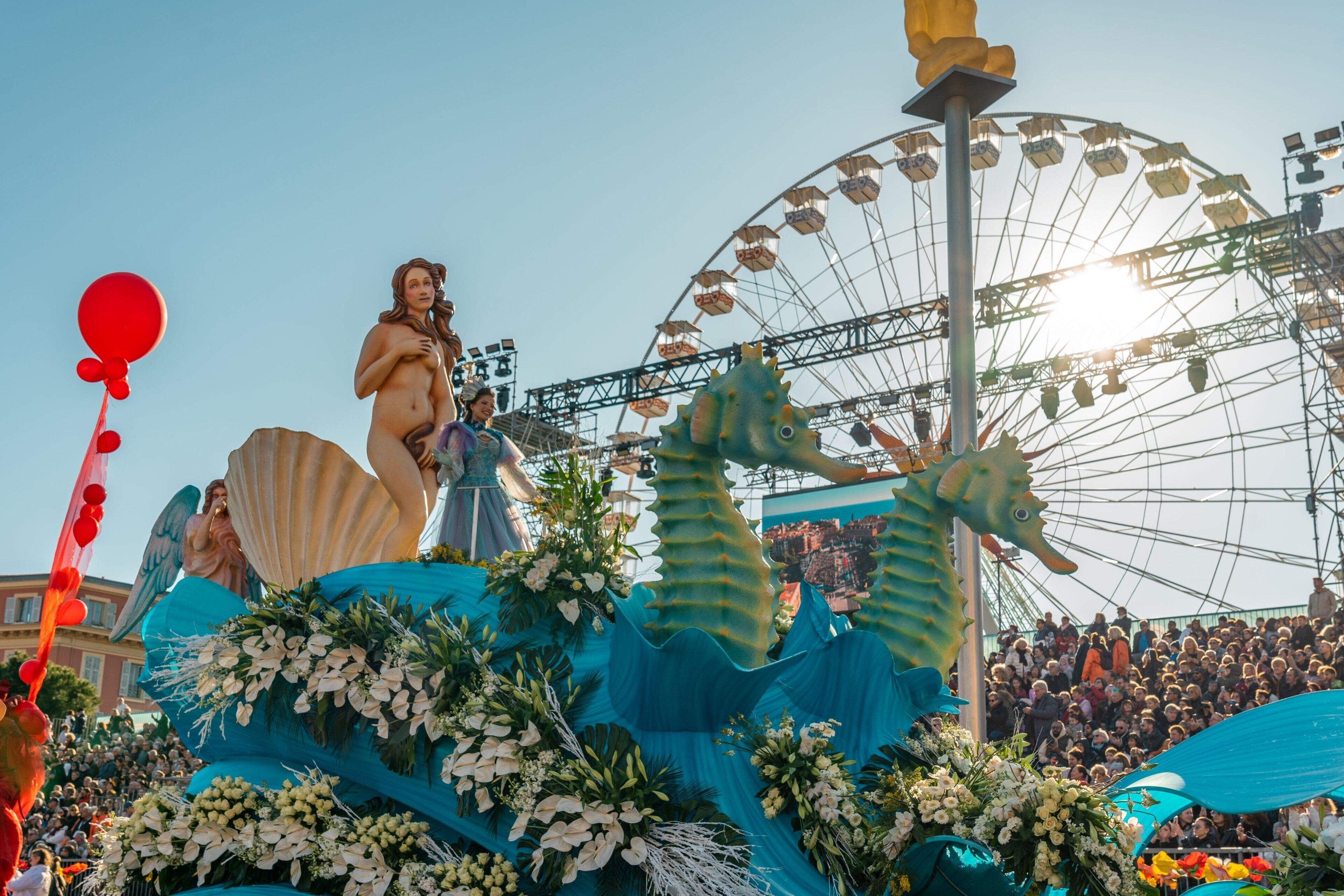 A parade float with a mermaid, seahorses, and a Ferris wheel in the background.
