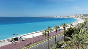 Una carretera costera con playa y palmeras.