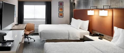 A hotel room with two beds, a desk, a chair, a television, and a large window.