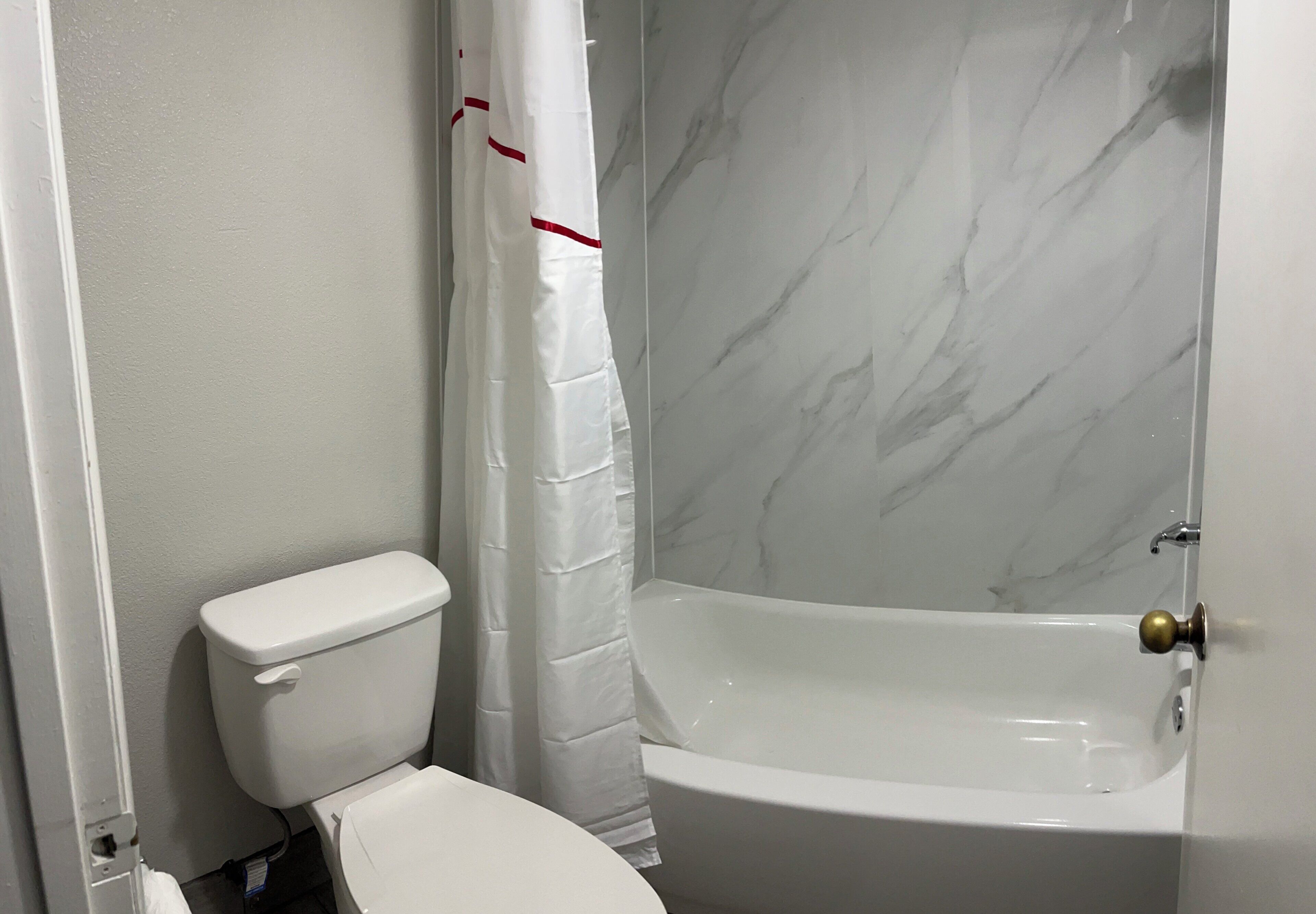 Un baño con inodoro, cortina de ducha y bañera.