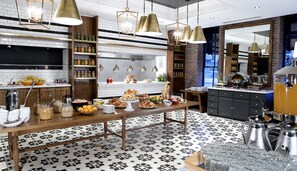 A modern kitchen with a large breakfast table, hanging pendant lights, and a coffee station. - DoubleTree by Hilton Ottawa Downtown (Ottawa)