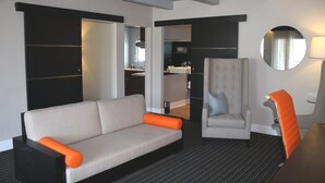 Une chambre d’hôtel moderne, équipée d’un canapé, d’un fauteuil et d’une petite table.