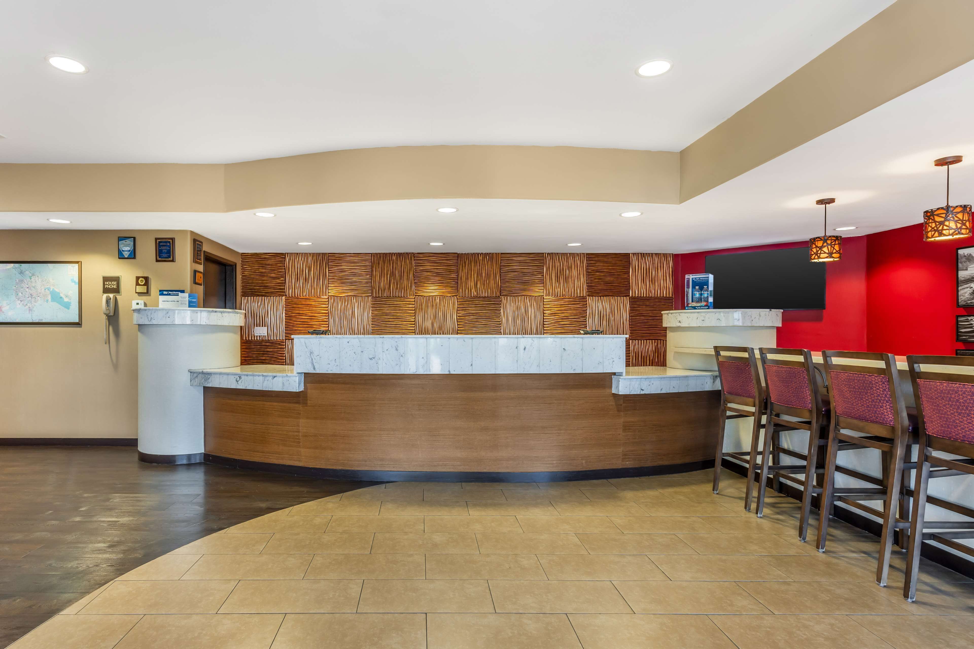 A reception area with a curved counter, wooden panel wall, and a red accent wall.