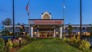 A Wine Country Inn & Suites with a large entrance, American flags, and well-lit exterior. - Best Western Plus Wine Country Inn & Suites (Santa Rosa)