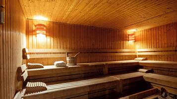 Una sauna con bancos de madera, un cubo y una toalla.