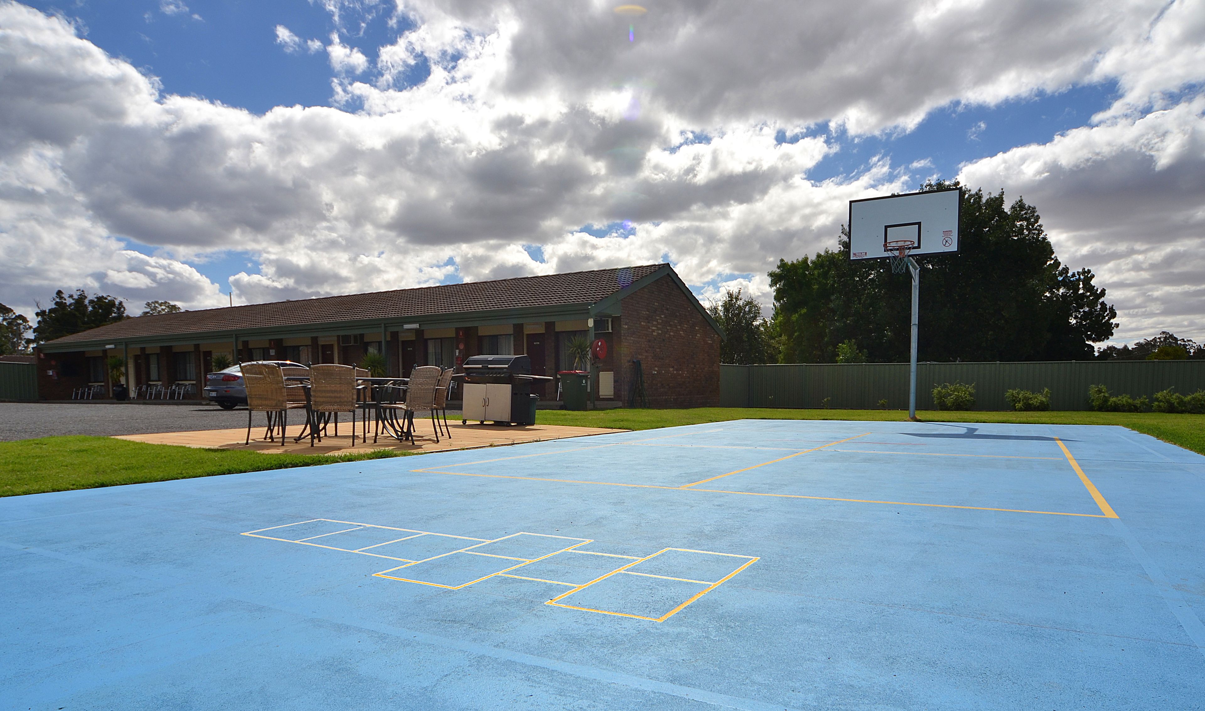 Una cancha de baloncesto con un edificio al fondo.