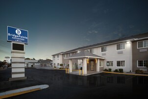 Hotel Bridge Pointe Advantage con entrada cubierta, estacionamiento y cielo despejado.