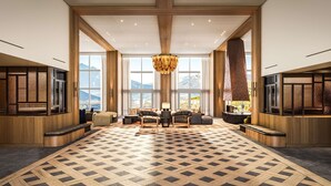 A spacious lobby with large windows, a herringbone patterned floor, and a central seating area. - Rimrock Banff, Emblems Collection (Banff)