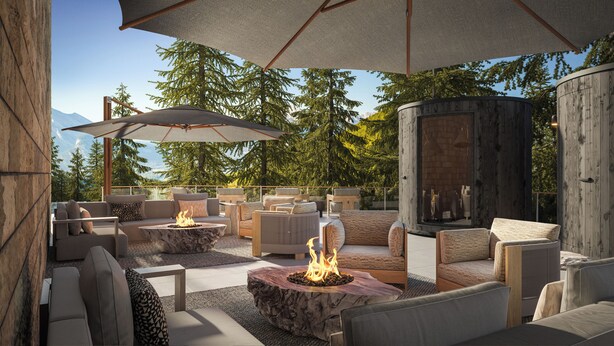 An outdoor seating area with fire pits, umbrellas, and a view of trees and mountains. - Rimrock Banff, Emblems Collection (Banff)