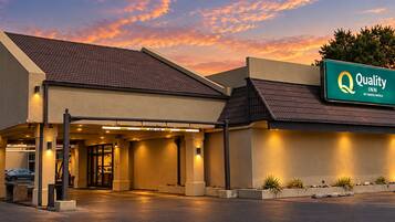 A hotel with a sign reading 'Quality Inn by Choice Hotels,' featuring a modern design with a flat roof and a covered entrance.