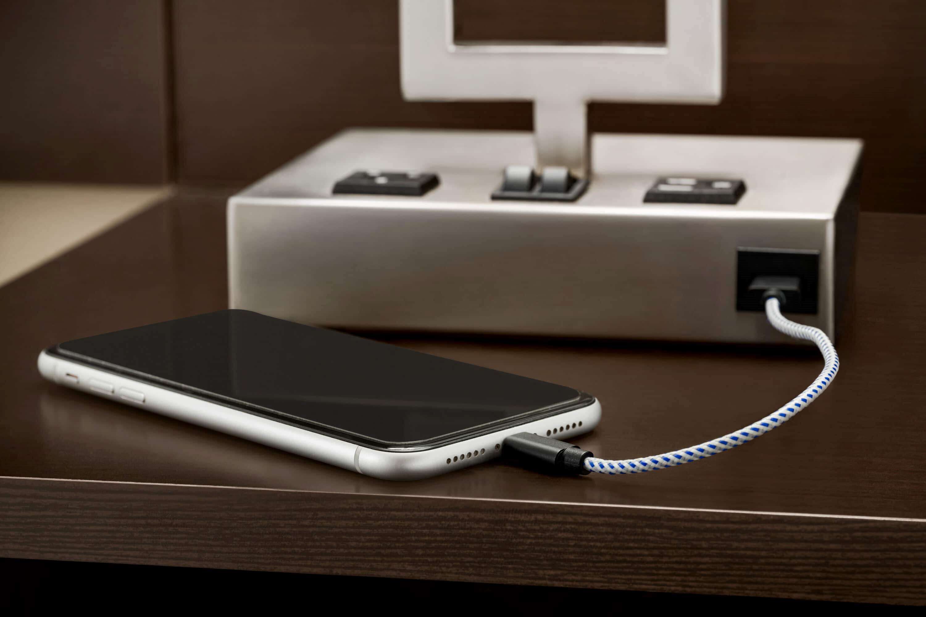 A smartphone connected to a charging dock with a cable.