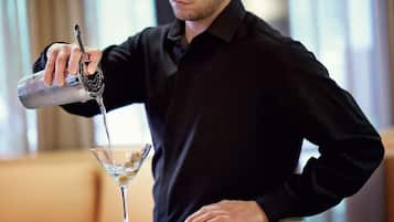 A person pouring a drink into a martini glass.