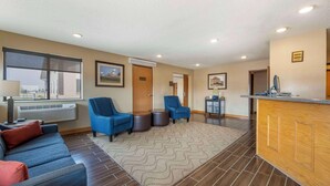 A hotel lobby with a sofa, two armchairs, a reception desk, and a large window. - Comfort Inn Lexington (Lexington)