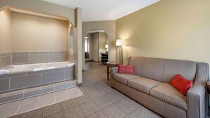 A hotel room with a bathtub, a sofa, and a lamp. - Comfort Inn Lexington (Lexington)
