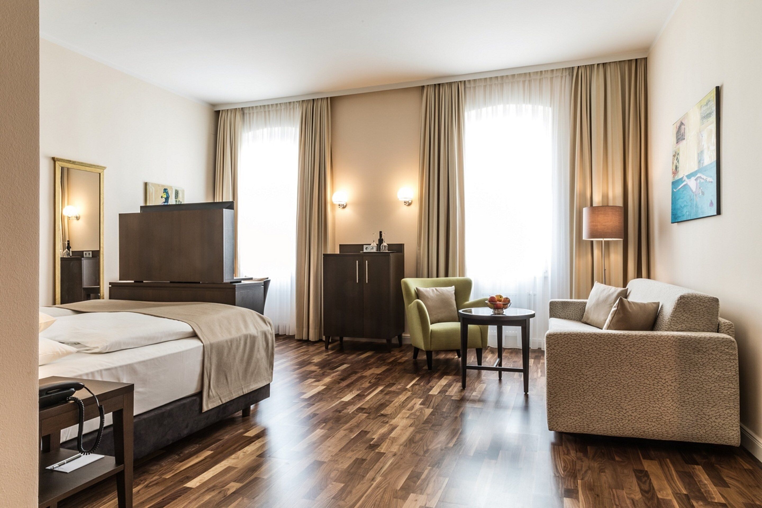 Een hotelkamer met een bed, een bureau, een stoel, een bank en een kledingkast.