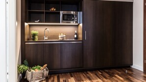 A compact kitchen with a microwave, sink, and storage cabinets.