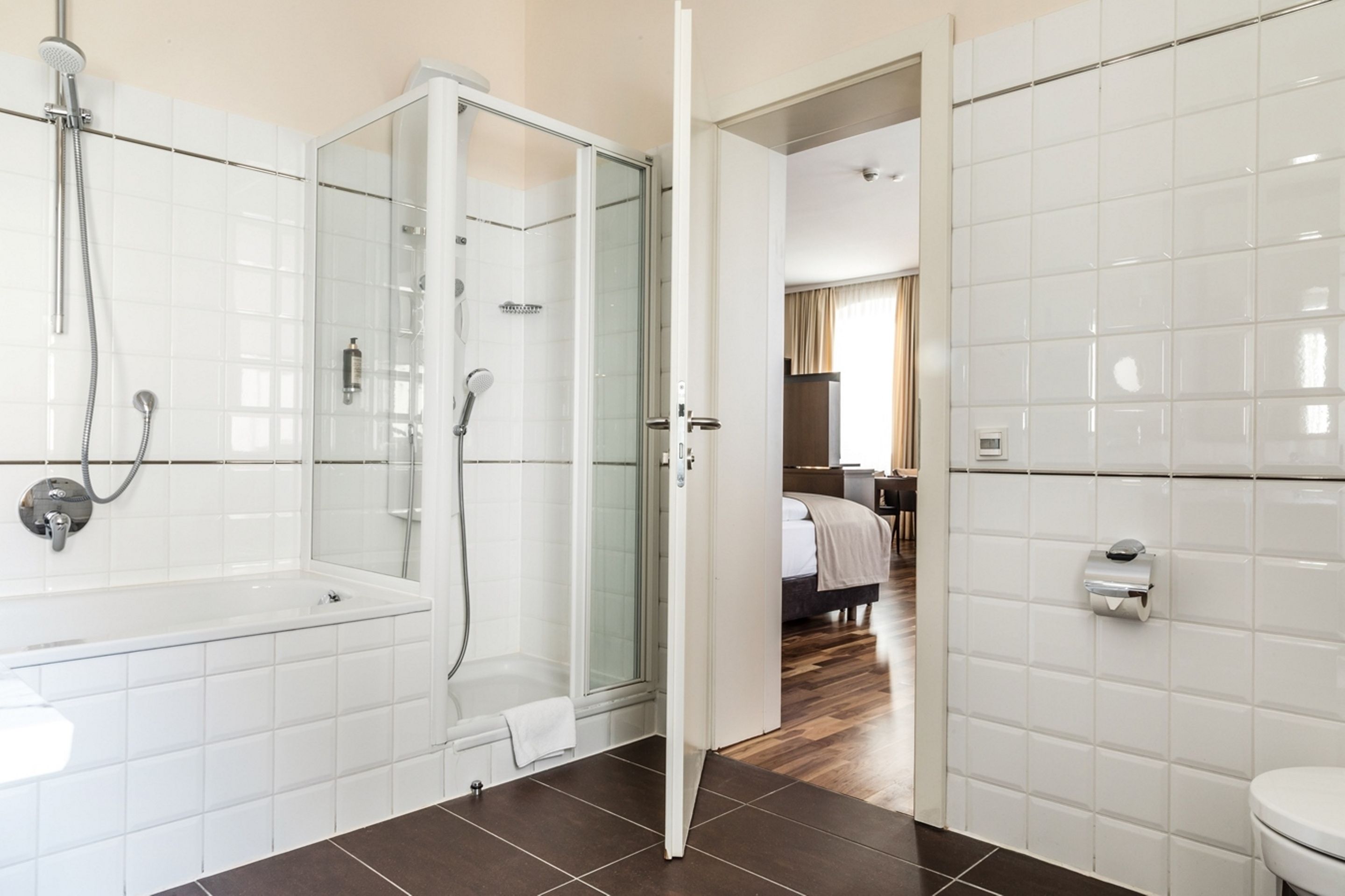A modern bathroom with a glass-enclosed shower, a standalone bathtub, and a toilet.