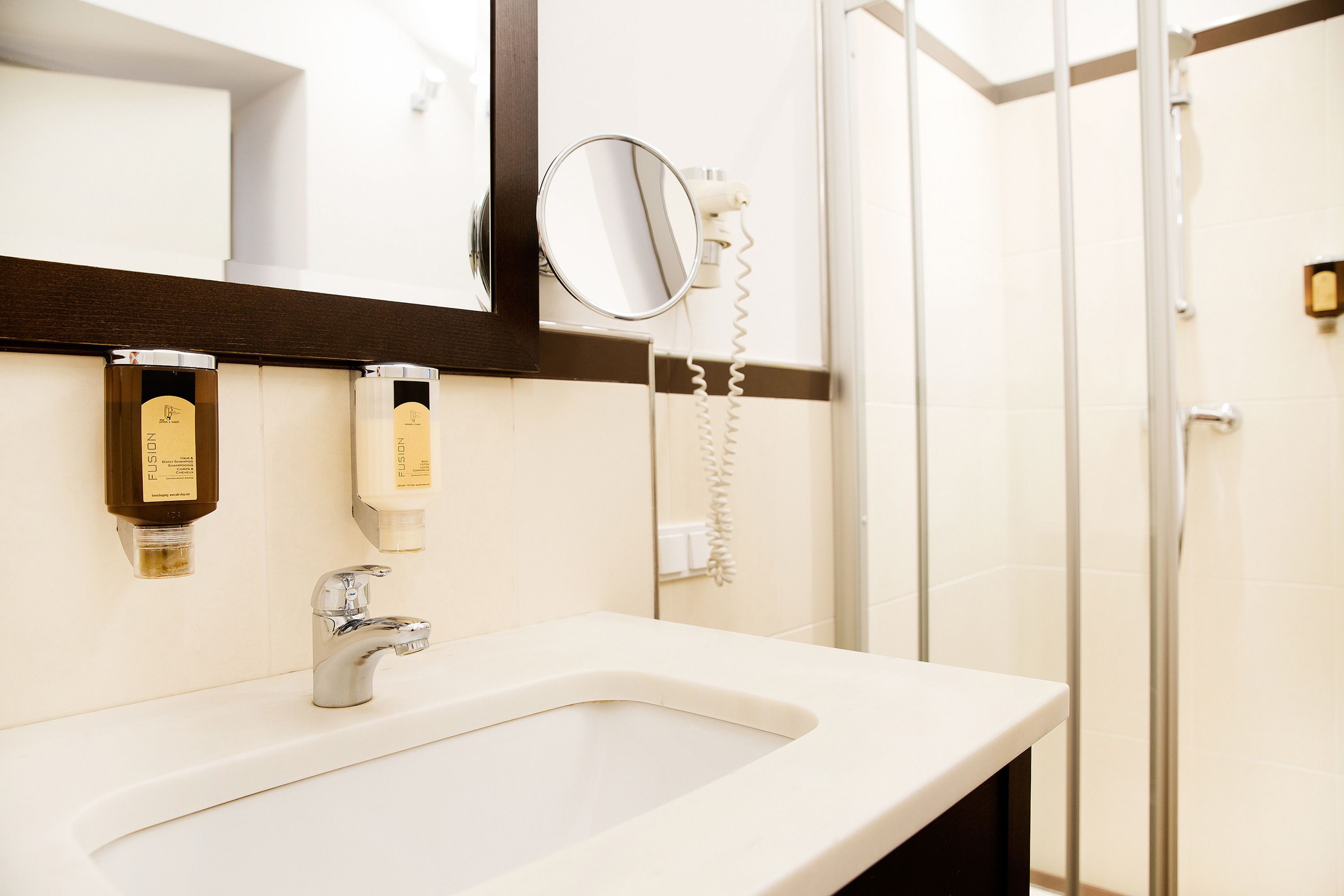 A bathroom with a sink, mirror, and toiletries.