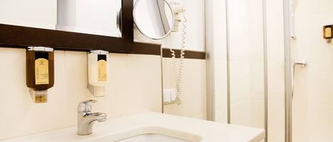 A bathroom with a sink, mirror, and toiletries.