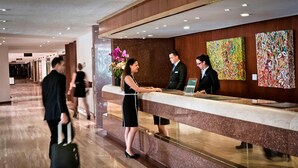 A hotel reception area with a marble counter, a receptionist, and a guest. - Hotel Tamanaco Caracas (Caracas)