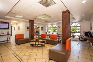 A hotel lobby with seating areas, a reception desk, and large windows. - Motel 6 Kingsport, TN (Kingsport)