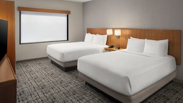 Une chambre d’hôtel avec deux lits, une télévision et un écran de projection.