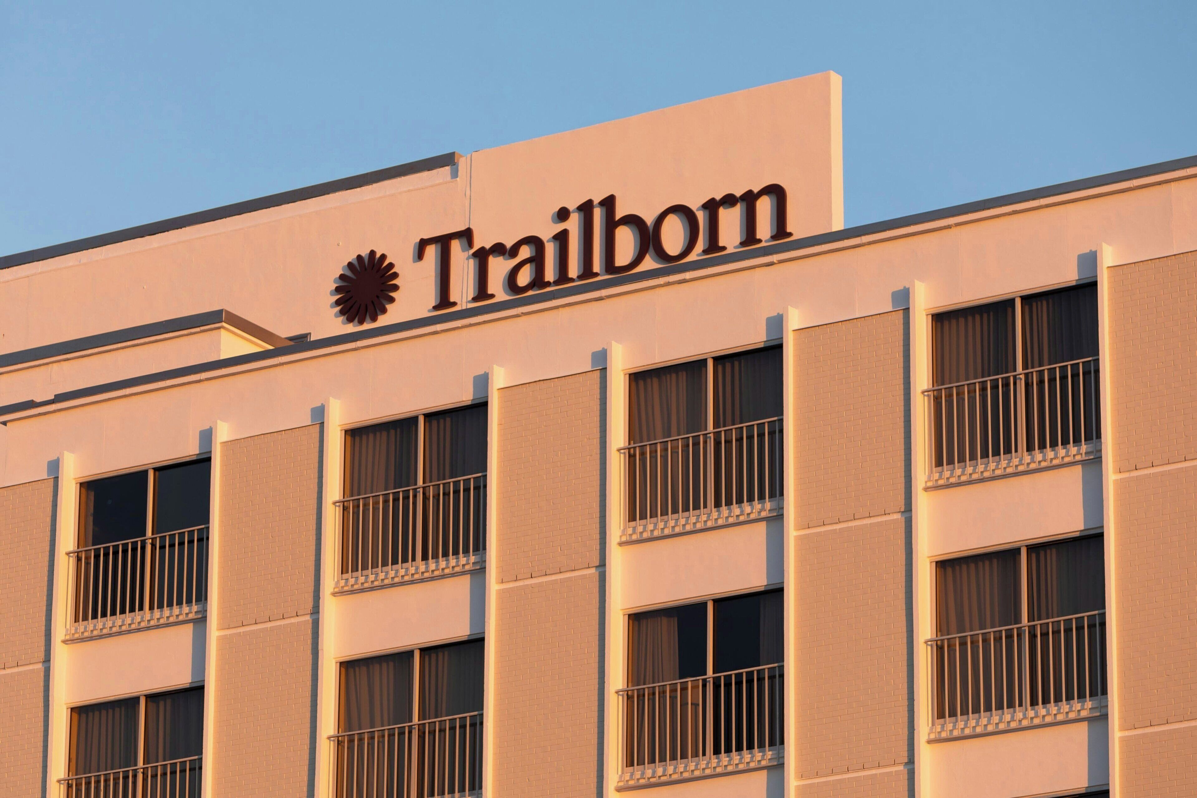 A building with a sign reading "Trailborn" and multiple windows with metal railings.