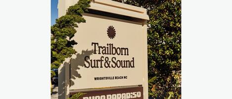 Letrero que dice 'Trailborn Surf & Sound', 'Wrightsville Beach NC' y 'Duna Paradiso'.