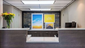 Ein Empfangsschalter mit Blumenstrauß, gerahmten Bildern und einem Drucker.