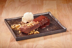 Un dolce su un piatto rettangolare con sfondo in legno.