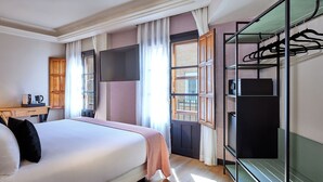 A hotel room with a bed, a desk with a coffee maker, a wardrobe, and a window with curtains. - Boutique Hotel Luna Triunfo Granada *NEW* (Granada)