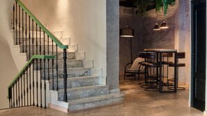 A staircase with marble steps and green handrails, leading to a seating area with bar stools and a hanging light fixture. - Boutique Hotel Luna Triunfo Granada *NEW* (Granada)