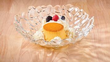 A clear glass bowl with a dessert on a wooden surface.