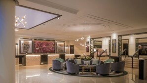 A modern lobby with a reception desk, seating area, and a staircase. - Conrad Dublin (Dublin)